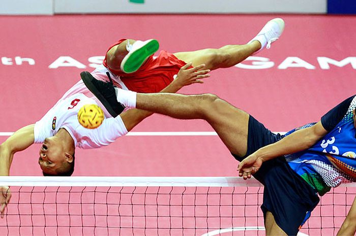 Pemain sepak takraw putra Indonesia Nofrizal (kiri) menendang bola dihalangi pemain India Yumnam Akhas dalam pertandingan penyisihan tim beregu putra cabang olahraga sepak takraw Asian Games 2018 di GOR Ranau, Jakabaring Sport City (JSC), Palembang, Sumatera Selatan, Senin (20/8/2018).