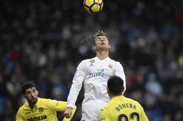 Bintang Real Madrid, Cristiano Ronaldo (tengah), menyundul bola di antara kawalan pemain Villarreal dalam partai Liga Spanyol di Santiago Bernabeu, 13 Januari 2018.