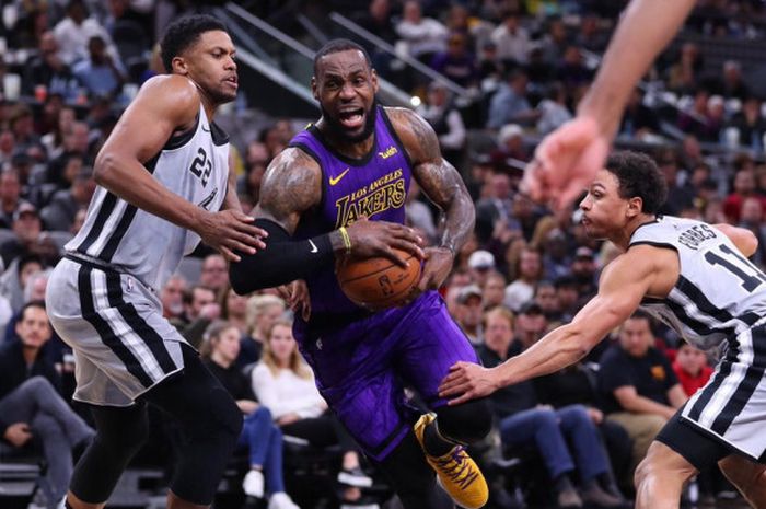 Pemain LA Lakers, LeBron James (jersey ungu), saat berusaha menembus pertahanan San Antonio Spurs da