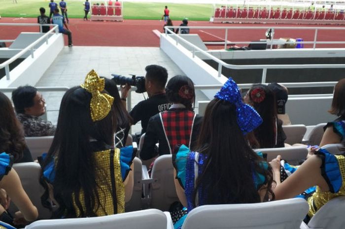 Sejumlah anggota JKT48 bersiap untuk tampil pada jeda laga persahabatan antara Bhayangkara FC kontra FC Tokyo sembari duduk di tribune Stadion Utama Gelora Bung Karno (SUGBK), Senayan, Jakarta, Sabtu (27/1/2018).