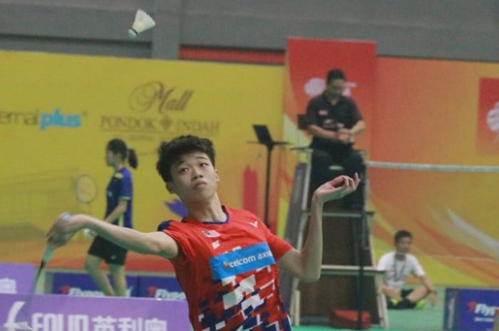 Seorang pebulu tangkis junior asal Malaysia sedang berupaya mengembalikan kok ke lawan bertandingnya pada ajang PB Jaya Raya Badminton Asia Junior Championship 2018.