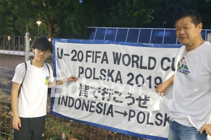 Dua orang suporter timnas U-19 Jepang yang mengaku sebagai Ultra Nippon, Seiya Inoue (kiri) dan Toshitada Suzuki (kanan), memasang banner dukungan untuk timnas U-19 Jepang di sudut pagar Lapangan ABC, Senayan, Jakarta, Sabtu (27/10/2018).