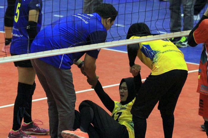 Kapten tim bola voli Bandung Bank BJB Pakuan,Wilda Siti Nurfadhilah, sedang dibantu berdiri saat mengalami cedera melawan Jakarta Elektrik PLN pada putaran pertama Proliga 2018 di GOR Ken Arok, Malang, Jumat (30/3/2018).