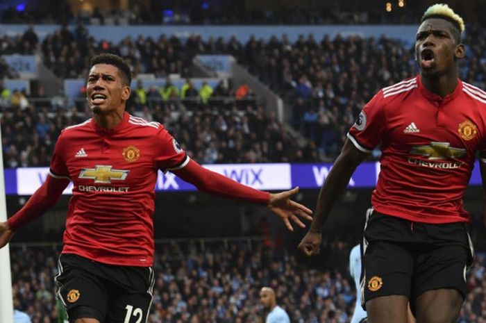 Pemain Manchester United, Chris Smalling (kiri) dan Paul Pogba, merayakan gol ketiga Man United ke gawang Man City pada laga Derbi Manchester di Stadion Etihad, Manchester, pada Sabtu (7/4/2018).