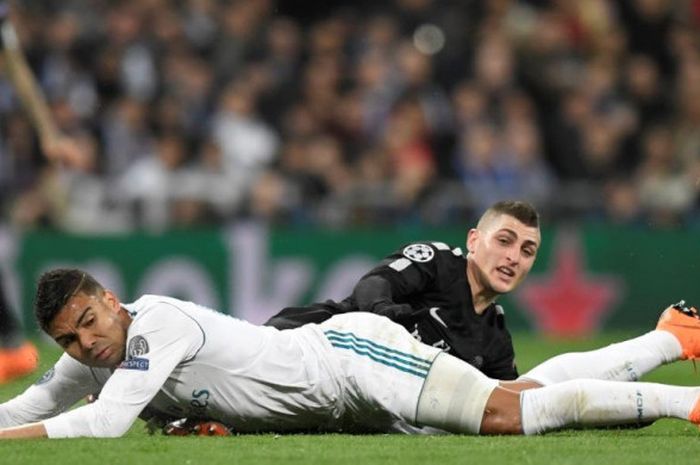 Gelandang Real Madrid, Casemiro (kiri), terjatuh saat berduel dengan pemain Paris Saint-Germain, Marco Verratti, dalam partai Liga Champions di Stadion Santiago Bernabeu, Madrid, 14 Februari 2018.