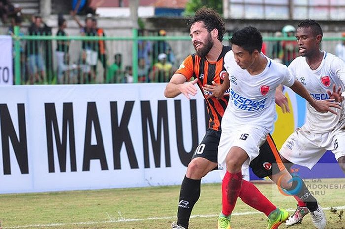 Gelandang PSM Makassar Muhammad Arfan berduel dengan pemain Perseru Serui