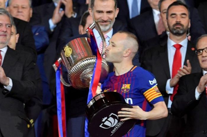 Kapten FC Barcelona, Andres Iniesta, mencium trofi juara Copa del Rey setelah timnya mengalahkan Sevilla di Stadion Wanda Metropolitano, Madrid, 21 April 2018.