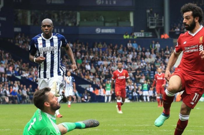 Penyerang sayap Liverpool, Mohamed Salah (kanan), melepaskan tembakan yang berujung gol ke gawang West Bromwich Albion kawalan Ben Foster dalam partai Liga Inggris di Stadion The Hawthorns, West Bromwich, 21 April 2018.