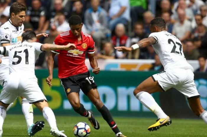 Striker Manchester United, Marcus Rashford, mengontrol bola di tengah kawalan pemain Swansea City dalam partai Liga Inggris di Stadion Liberty, 19 Agustus 2017.