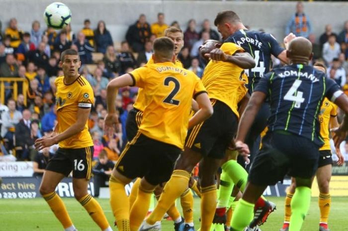 Bek Manchester City, Aymeric Laporte (dua dari kanan), menanduk masuk bola hasil umpan sepak pojok ke gawang Wolverhampton Wanderers dalam partai Liga Inggris di Molineux Stadium, Wolverhampton, 25 Agustus 2018.