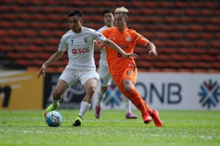 Bek Hanoi FC, Sam Ngoc Duc (kiri) mencoba mengamankan bola dari penyerang Felda United, Lucas Cano, 