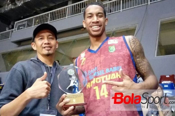 Pemain asing BSB Hangtuah, Nashon George (kanan), didampingi Manajer Tim Ferry Jufri berpose dengan trofi Slam Dunk Contest yang diraihnya pada ajang IBL Pertalite All-Star Game 2018 di BritAma Arena Mahaka Square, Kelapa Gading, Jakarta, Minggu (7/1/2018).