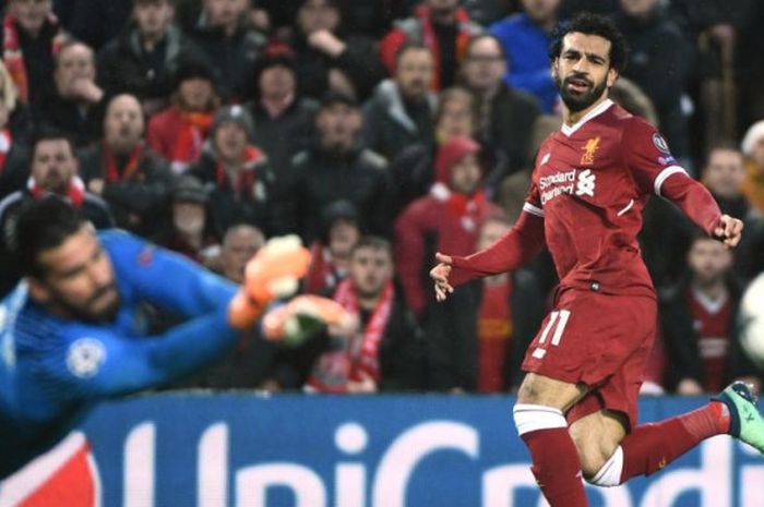 Striker Liverpool, Mohamed Salah (kanan), melepaskan tembakan yang coba dihalau kiper AS Roma, Alisson Becker, dalam partai Liga Champions di Stadion Anfield, Liverpool, 24 April 2018.