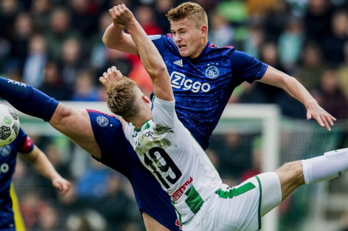 Aksi bek Ajax Amsterdam, Matthijs de Ligt (kakan), dan penyerang Groningen, Tom van Weert, saat berebut bola dalam laa Liga BElanda 2017-2018 di Stadion Euroborg, Groningen, Belanda, pada 1 April 2018.