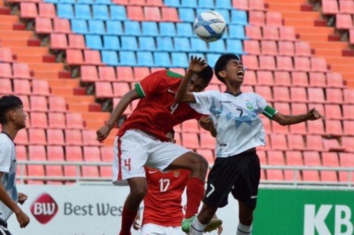 Duel di udara bek timnas U-16 Indonesia, Ahmad Rusadi dengan kapten timnas U-16 Timor Leste, Jhon Frith Ornai Liu (kanan) pada laga kedua Grup G Kualifikasi Piala Asia U-16 2018 di Stadion Rajamangala, Bangkok, Thailand, Senin (18/9/2017) sore. 