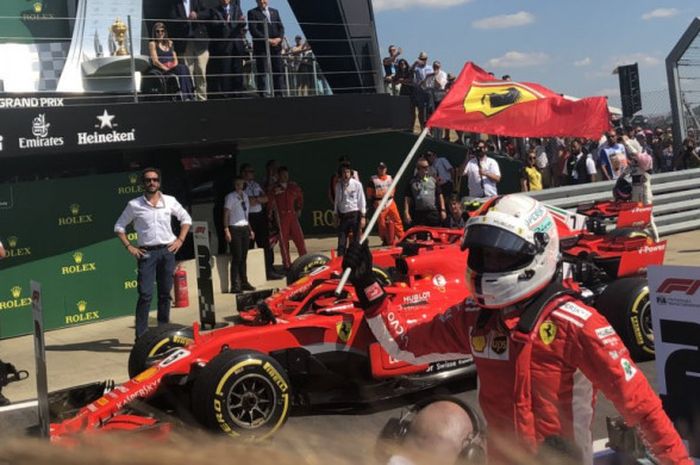 Sebastian Vettel merayakan kemenangannya saat balapan GP Inggris di SIrkuit Silverstone, Inggris, Minggu (8/7/2018).