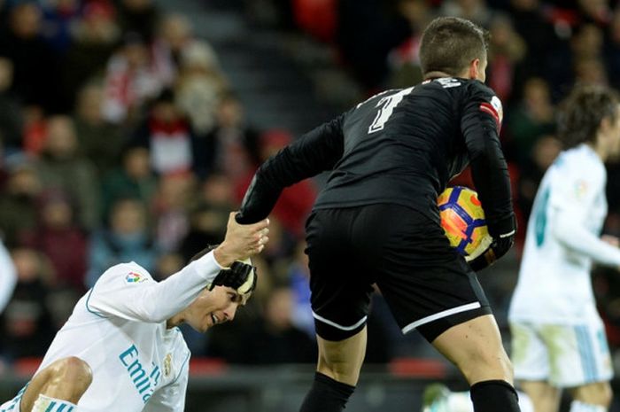 Kiper Athletic Bilbao, Kepa Arrizabalaga, membantu megabintang Real Madrid, Cristiano Ronaldo, untuk berdiri dalam laga Liga Spanyol di Stadion San Mames, Bilbao, pada 2 Desember 2017.