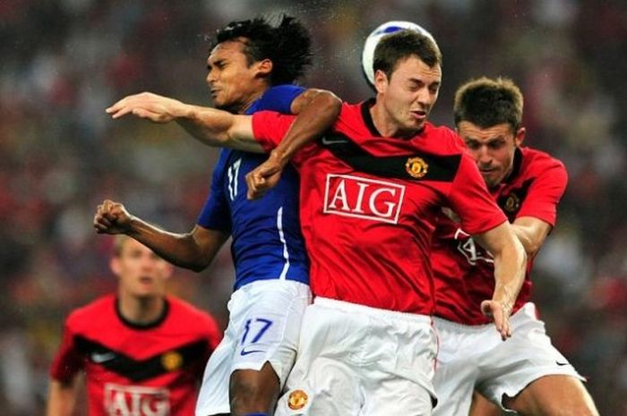 Duo pemain Manchester United, Jonny Evans (tengah) dan Michael Carrick duel di udara dengan penyerang Mohd Amri Yahyah dari Malaysia XI pada laga pemanasan pra-musim di Stadion Nasional Bukit Jalil, Kuala Lumpur, Malaysia, 20 Juli 2009.