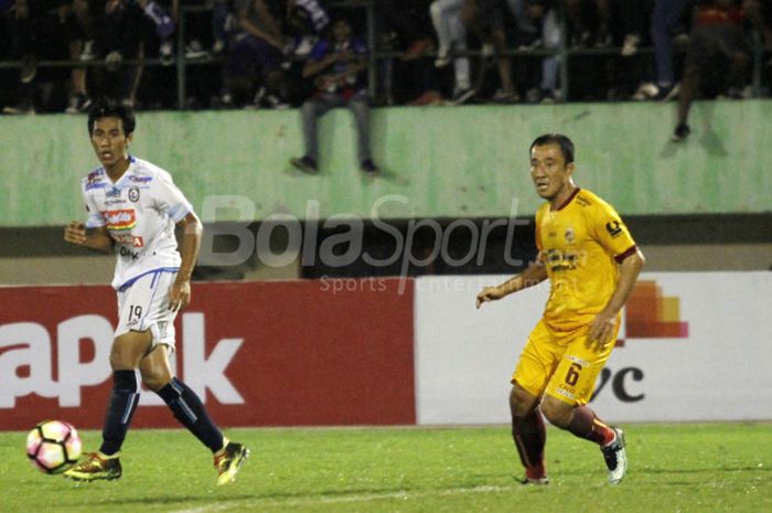 Pemain Arema FC Hanif Sjahbandi (kiri) dan gelandang Sriwijaya FC, Yu Hyun Koo (kanan) di laga  perempat final Piala Presiden, Minggu (4/2/2018). 