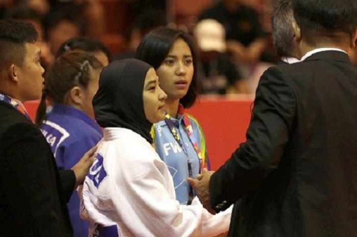 Pejudo putri Indonesia Miftahul Jannah (tengah) berunding dengan perangkat pertandingan sebelum bertanding di kelas kelas 52 kg blind judo Asian Para Games 2018 di Jiexpo Kemayoran, Jakarta, Senin (8/10). Pejudo asal Aceh itu didiskualifikasi karena tidak mau melepas jilbabnya saat bertanding.