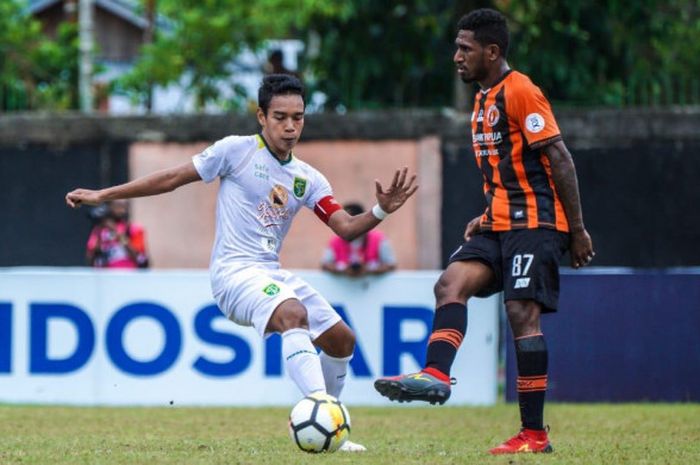 Kapten Persebaya, Misbakus Solikin (kiri), berhadapan dengan gelandang Perseru, Makarius Fredik Suruan, dalam duel Liga 1 2018 antara Perseru kontra Persebaya di Stadion Marora, Serui, Selasa (31/7/2018).