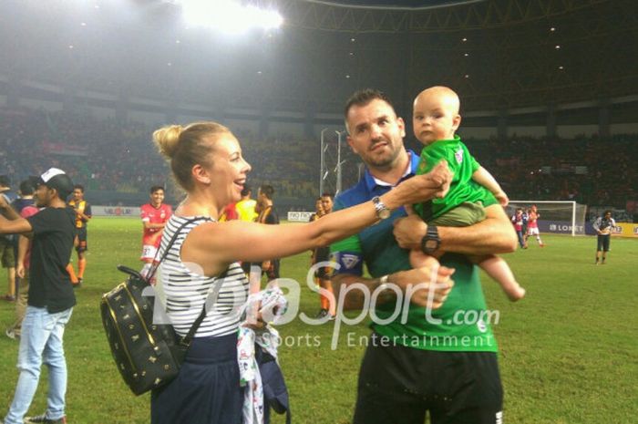 Pelatih Bhayangkara FC, Simon McMenemy, merayakan keberhasilan timnya menjuarai Liga 1 bersama istri dan anaknya usai laga melawan Persija Jakarta, di Stadion Patriot Chandrabhaga, Bekasi, Minggu (12/11/2017).