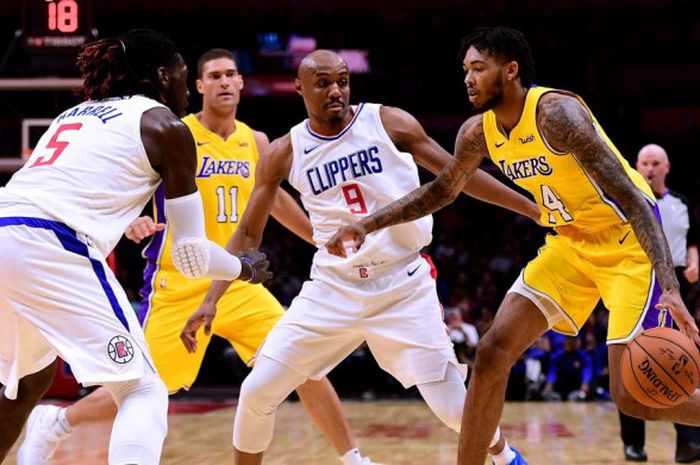 Pebasket Los Angeles Lakers, Brandon Ingram, mendribel bola seraya dijaga dua pemain Los Angeles Clippers pada lanjutan musim reguler NBA 2018-2019 di Staples Center, Los Angeles, California, Amerika Serikat (AS), Jumat (28/12/2018).