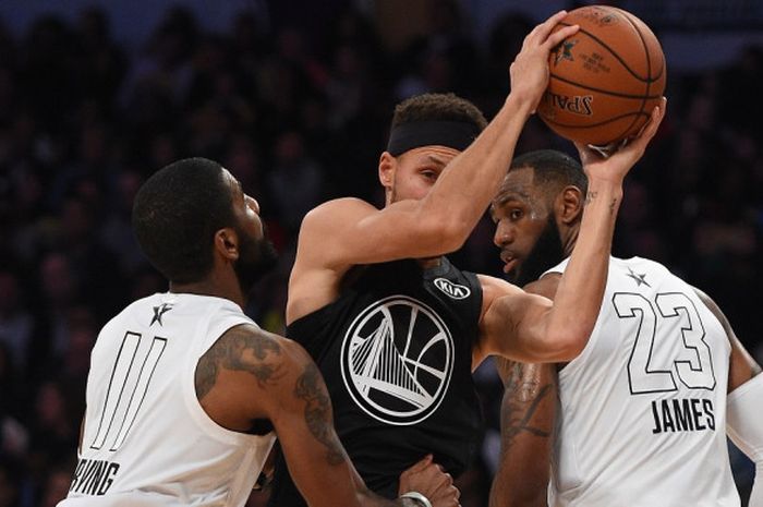 Pebasket bintang Golden State Warriors, Stephen Curry (jersey hitam), berupaya melewati penjagaan Kyrie Irving (kiri) dan LeBron James (kanan) pada laga NBA All-Star 2018 yang digelar di Staples Center, Los Angeles, California, Amerika Serikat (AS), Minggu (18/2/2018) malam waktu setempat atau Senin pagi WIB.