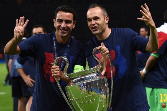 Andres Iniesta (kanan) dan Xavi Hernandez berpose dengan trofi saat dipastikan menjuarai Liga Champions pada 2015 di Olympiastadion, Berlin. 