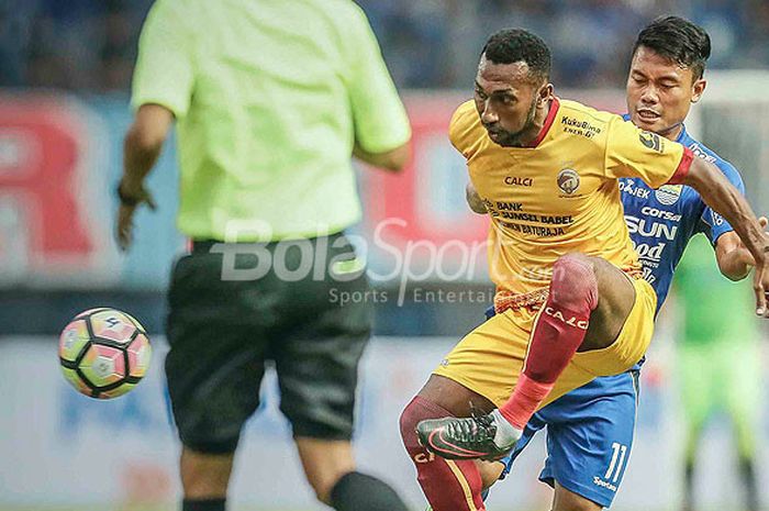 Pemain depan Sriwijaya FC, Patrich Wanggai (kiri), berebut bola dengan gelandang Persib Bandung, Dedi Kusnandar, dalam laga pembuka Piala Presiden 2018 di Stadion Gelora Bandung Lautan Api, Kab. Bandung, Selasa (16/1/2018).