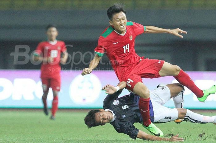 Pemain Timnas U-19 Indonesia,berduel dengan pemain Timnas U-19 Kamboja, Chhoeung Visinu, dalam laga di Stadion Patriot Candrabhaga, Rabu (4/10/2017).