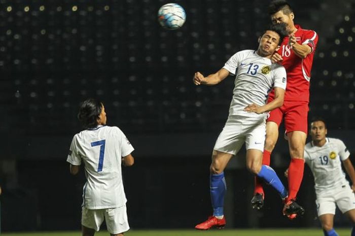 Duel udara antara penyerang timnas Malaysia, Syafiq Ahmad (13) dengan gelandang timnas Korut,Ri Yong-Chol pada laga Kualifikasi Piala Asia 2019 di Stadion New I-Mobile, Buriram, Thailand, 14 November 2017. 