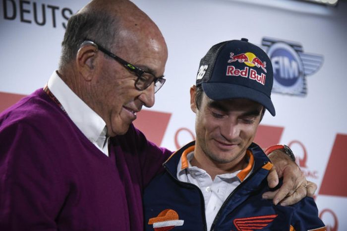   CEO Dorna Sport, Carmelo Ezpeleta (kiri), merangkul Dani Pedrosa saat sang pebalap mengumukan pensiun.