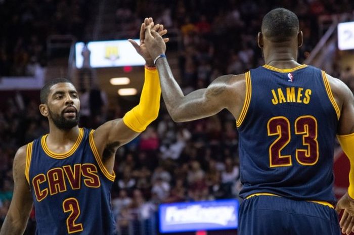 Pebasket Cleveland Cavaliers, LeBron James (kanan, #23), melakukan tos dengan rekan setim, Kyrie Irving, saat menjalani laga melawan Boston Celtics pada pertandingan pra-musim NBA 2016-2017.