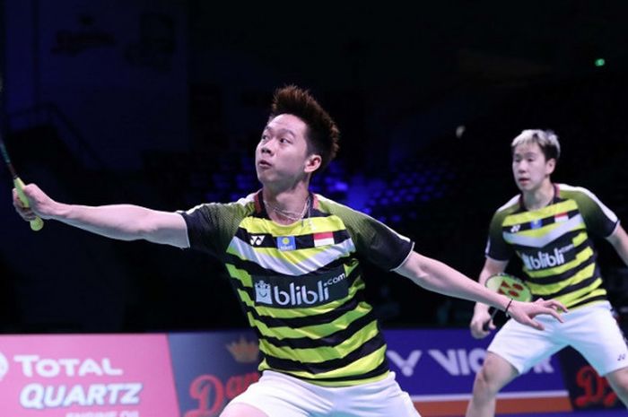 Pasangan ganda putra Indonesia, Marcus Fernaldi Gideon/Kevin Sanjaya Sukamuljo, mengembalikan kok ke arah Takuro Hoki/Yugo Kobayashi (Jepang) pada babak perempat final Denmark Open 2018 yang berlangsung di Odense Sports Park, Kamis (19/10/2018).