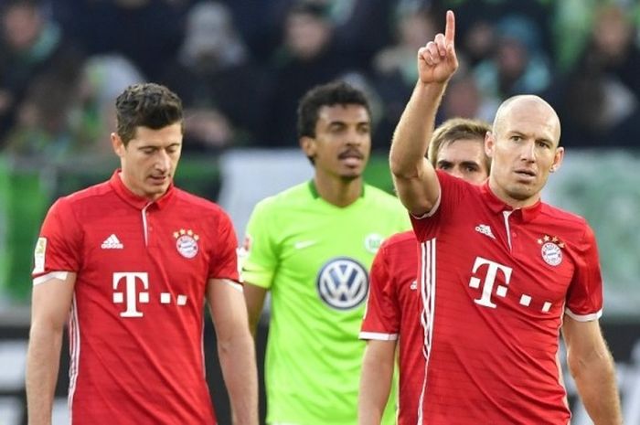 Striker FC Bayern Muenchen, Robert Lewandowski (kiri), tertunduk saat Arjen Robben (kanan) merayakan gol ke gawang Vfl Wolfsburg dalam pertandingan Bundesliga di Volkswagen Arena, Wolfsburg, Jerman, pada 29 April 2017.