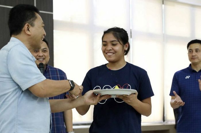 Pebulu tangkis tunggal putri Indonesia, Gregoria Mariska (kedua dari kanan) mendapat potongan tumpeng pertama dari Sekjen PP PBSI Achmad Budiharto dalam acara syukuran atas rampungnya renovasi asrama putra dan putri Pelatnas PBSI Cipayung di ruang serbaguna PBSI, Kamis (26/7/2018).