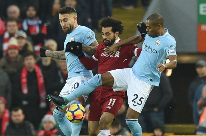  Pemain Manchester City, Nicolas Otamendi (kiri) dan Fernandinho (kanan), mengawal pergerakan winger Liverpool FC, Mohamed Salah, dalam laga Liga Inggris di Stadion Anfield, Liverpool, pada 14 Januari 2018. 