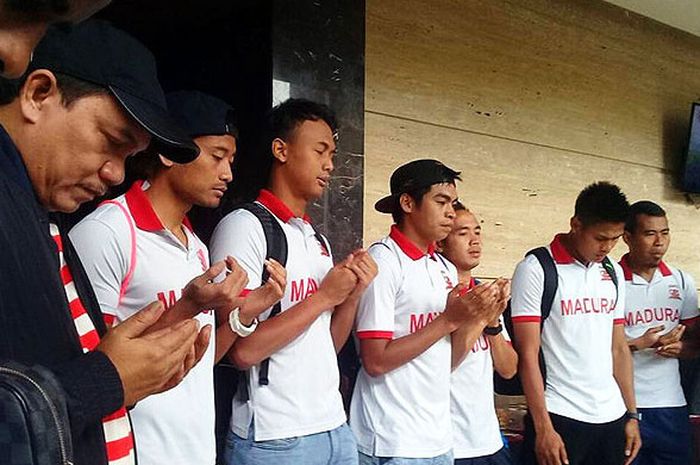 Presiden Madura United, Achsanul Qosasi (kedua dari kiri), berdoa bersama pemain menjelang keberangkatan ke Balikpapan untuk melawan Persiba Balikpapan dalam laga lanjutan Liga 1 di Stadiion Batakan, Balikpapan.