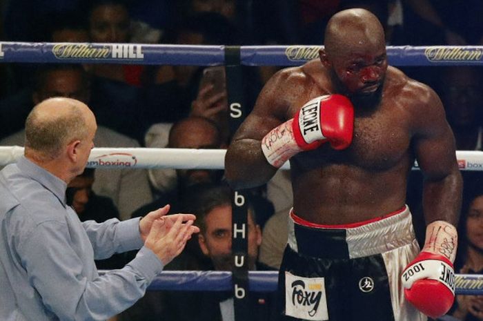 Wasit Phil Edwards memeriksa luka yang diterima petinju kelas berat asal Prancis, Carlos Takam, pada duel melawan Anthony Joshua (Inggris) di Principality Stadium, Cardiff, Wales, Sabtu (28/10/2017). Joshua dinyatakan menang TKO atas Takam pada ronde ke-10.