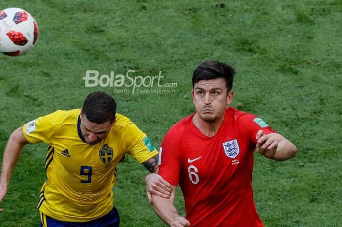 Bek Inggris, Harry Maguire (kanan), memperebutkan bola dengan penyerang Swedia, Marcus Berg.