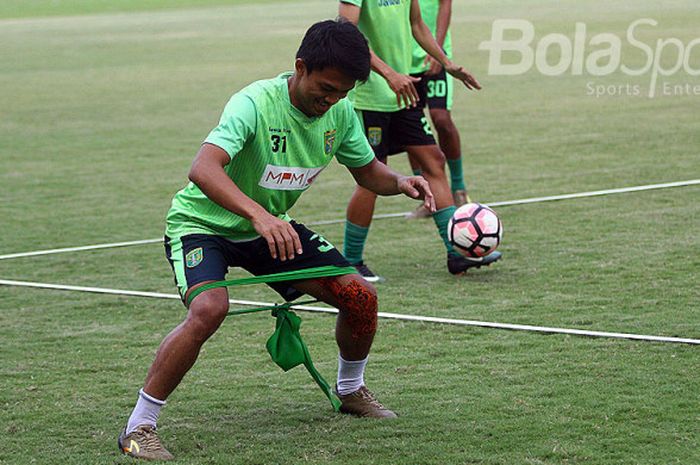 Pemain Persebaya, Kurniawan Karman, saat melakukan penguatan otot kaki kanan yang cedera saat latihan di Gelora Bung Tomo.