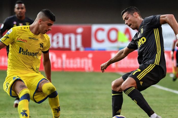 Megabintang Juventus, Cristiano Ronaldo (kanan), berduel dengan gelandang Chievo, Fabio Depaoli, dalam laga Liga Italia di Stadion Marcantonio Bentegodi, Verona pada 18 Agustus 2018.