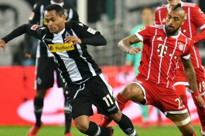 Gelandang Bayern Muenchen, Arturo Vidal (kanan), berduel dengan gelandang Borussia Moenchengladbach, Raffael, dalam duel kedua tim di ajang Liga Jerman di Stadion Im-Borussia Park pada Minggu (26/11/2017) dini hari WIB. 