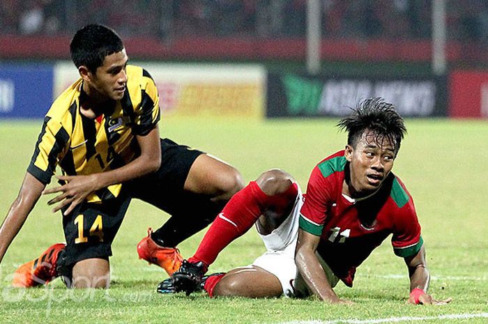        Gelandang timnas U-16 Indonesia, Mochammad Supriadi (kanan), dilanggar pemain Malaysia pada laga semifinal Piala AFF U-16 2018 di Stadion Gelora Delta Sidoarjo, Jawa Timur, Kamis (09/08/2018) malam.       