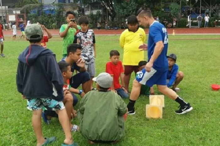 Kim Jeffrey Kurniawan berlatih didampingi fisioterapi Benidektus Adi Priyanto, dikerumuni anak-anak dan menjadi bahan tontonan. 