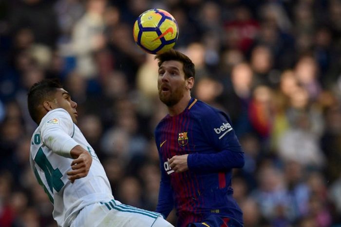 Megabintang FC Barcelona, Lionel Messi (kanan), berduel dengan gelandang Real Madrid, Casemiro, dalam laga Liga Spanyol di Stadion Santiago Bernabeu, Madrid, pada 23 Desember 2017.