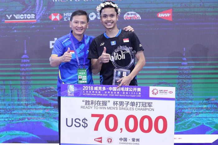 Pebulu tangkis tunggal putra Indonesia, Anthony Sinisuka Ginting, berpose di atas podium juara bersama sang pelatih, Hendry Saputra, setelah mengalahkan Kento Momota (Jepang) pada laga final turnamen China Open 2018 di Changzhou, Minggu (23/9/2018).