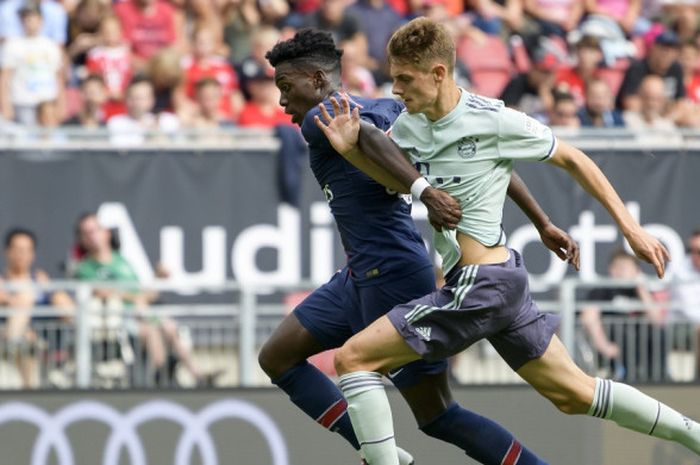 Penyerang Paris Saint-Germain, Timothy Weah (kiri), berduel dengan pemain Bayern Muenchen, Josip Stanisic, dalam laga International Champions Cup di Stadion Worthersee, Klagenfurt, Austria pada 21 Juli 2018.