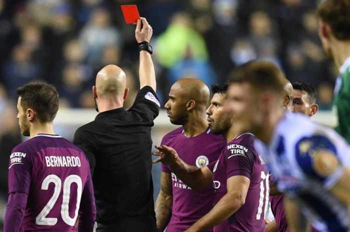 Wasit Anthony Taylor (kedua dari kiri) memberikan kartu merah untuk bek kiri Manchester City, Fabian Delph, dalam laga babak kelima Piala FA kontra Wigan Athletic di Stadion DW, Wigan, Inggris, pada 19 Februari 2018.